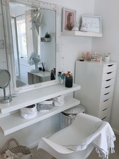 a white dressing table with mirror, stool and other items on the shelf in front of it