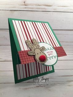 a close up of a christmas card with a reindeer on the front and red nose