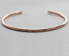 "A hammered cuff made with 14K rose gold fill, this is your perfect minimal bracelet for everyday wear. Simple design features a hammered finish and flattened, rounded ends. Lightly polished and tumbled for strength and shine. Bracelet is about 2mm thick with tapered ends. Your bracelet will be ready to ship one week after your order is placed. SIZING INFO Extra small: Length of 4.75 inches (about 5.75 inches including the opening). Widest point (inside measurement) is approximately 2 inches. Fo Plain Bracelet, Rose Gold Cuff Bracelet, Hammered Cuff Bracelet, Pinky Rings, Gold Bracelet Simple, Minimal Bracelet, Gold Cuff Bracelet, Bracelet Rose Gold, The Bangles