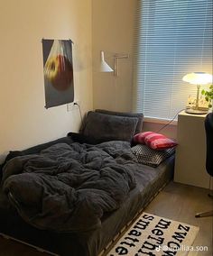 an unmade bed sitting in the corner of a room