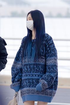 a woman with blue hair wearing a face mask