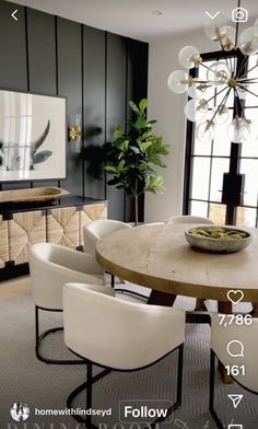 a dining room table surrounded by white chairs