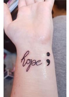 a small wrist tattoo with the word hope on it