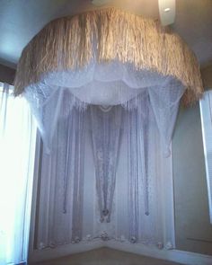 a canopy bed with curtains and lights hanging from it