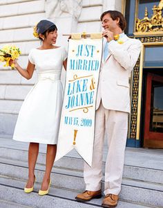 a man and woman standing next to each other in front of a sign that says, 5 the way her pastel yellow shoes, vell