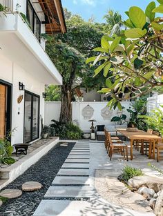 an outdoor dining area is shown in this modern style house with white walls and windows