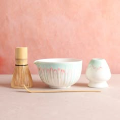 two bowls and a whisk are sitting on the table next to each other