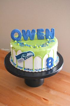 a birthday cake with the number eight on it, decorated in blue and green icing