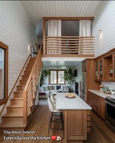 an open concept kitchen and living room with stairs leading up to the second floor above