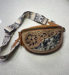 This bag is handtooled and designed and ready for a day at the rodeo, fair, vacation, or even your small daily  shopping trip. For an extra $75 I can make a matching tooled strap with your name, brand, initials or just matching florals!  PLEASE NOTE: If you choose a custom made strap the shipping time will take an extra two weeks!! Western Hand Tooled Bags For Daily Use, Western Hand-tooled Bag For Daily Use, Western Style Hand-tooled Bag For Daily Use, Western Style Hand-tooled Bags For Everyday Use, Western Hand Tooled Travel Bag, Hand Tooled Leather Bags For Rodeo, Hand Tooled Brown Bags For Rodeo, Leather Bags With Concho For Everyday Use, Western Style Hand-tooled Travel Bag