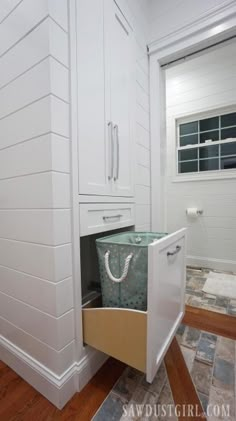 an open cabinet in the corner of a room with tile flooring and wood floors