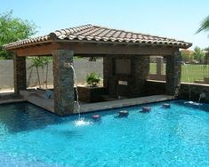 an outdoor pool with a gazebo next to it and water features on the sides