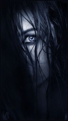 a woman's face with long hair and blue eyes is shown in the dark