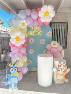 a birthday decoration with balloons and flowers on the front door to a house in california