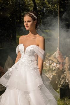 a woman in a white wedding dress with flowers on it