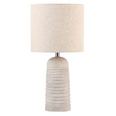 a white table lamp with a beige shade on the base and a light bulb in the middle