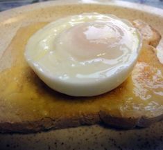 an egg yolk on top of some toasted bread with butter and syrup in the middle