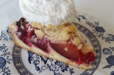 a piece of pie with whipped cream on top sits on a blue and white plate