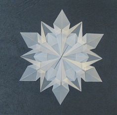 an origami snowflake on a black surface