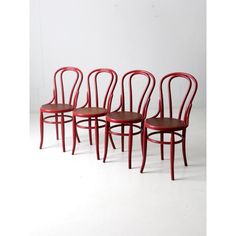 four red chairs sitting next to each other on a white surface with one chair in the middle