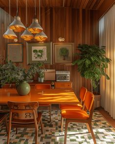 an orange dining table surrounded by chairs and potted plants in a room with wood paneling