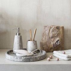 bathroom accessories including soap dispenser, toothbrush holder and sponges on a table