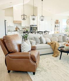 a living room filled with lots of furniture and decor on top of a hard wood floor