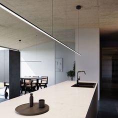 a kitchen counter with a sink and some chairs in the back drop off area next to it