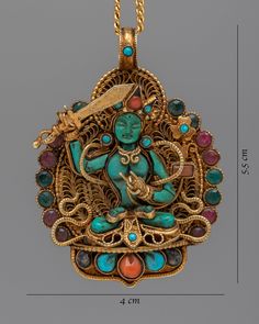 a gold and turquoise pendant with an image of a buddha in the center, surrounded by multi - colored stones