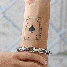 a person's arm with a tattoo on it and a chain around the wrist