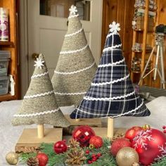 three small christmas trees sitting on top of a table