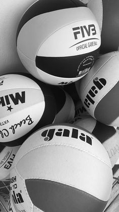 several white and black rugby balls stacked on top of each other