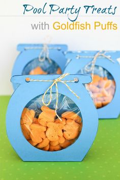 two blue boxes filled with goldfish puffs on top of a green table