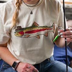 Saddle up and head to the lake with this cowboy trout tee!  If you're looking for a thick, structured tee that's also super soft and breathable--look no further! The Comfort Colors unisex garment-dyed heavyweight t-shirt ticks all the boxes and is made of 100% ring-spun cotton. The regular t-shirt style will complement most looks and fit you to a tee. * 100% ring-spun cotton * Fabric weight: 6.1 oz/yd² (206.8 g/m²) * Garment-dyed * Relaxed fit * 7/8″ double-needle topstitched collar * Twill-taped neck and shoulders for extra durability * Double-needle armhole, sleeve, and bottom hems * Blank product sourced from Honduras This product is made especially for you as soon as you place an order, which is why it takes us a bit longer to deliver it to you. Making products on demand instead of in Country Tee Shirts, Lake Fashion, Fish T Shirt, Chapeau Cowboy, Fishing Outfits, Cow Boy, Fishing T Shirts, Country Western, Outfit Inspo Fall