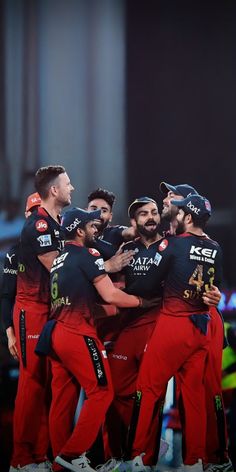 a group of men standing next to each other in front of a crowd wearing red pants