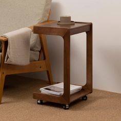 a small wooden table with a cell phone on it next to a couch and chair