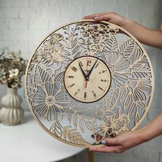 a person holding a wooden clock with flowers on it