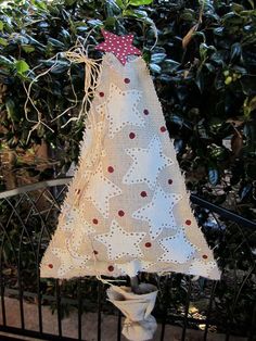 a small white christmas tree on top of a fence