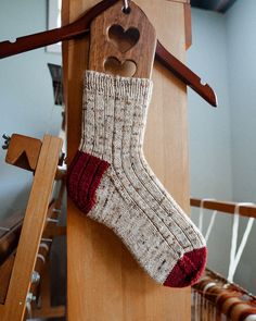 a pair of socks hanging from a wooden hanger with a heart on the top