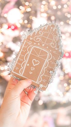 someone holding up a cut out of a gingerbread