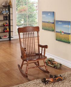 a wooden rocking chair sitting on top of a hard wood floor next to a window