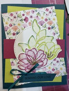 a close up of a card with flowers on it and a ribbon around the edge