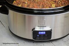 a slow cooker filled with food sitting on top of a table