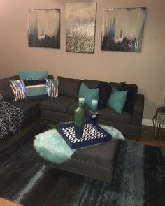 a living room with two couches, a coffee table and paintings on the wall