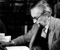 a man sitting at a table in front of a typewriter and writing on a piece of paper