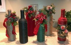 several wine bottles decorated with red and green ribbons, bows and poinsettis