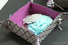 an open box with some fabric in it on a black counter top next to other items