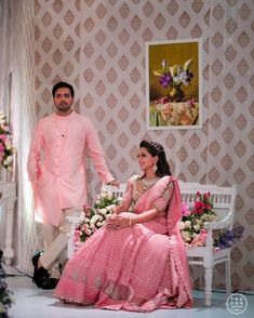 a man standing next to a woman in a pink dress