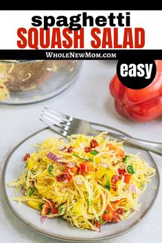 spaghetti salad on a plate with a fork and tomato in the background text reads spaghetti squash salad