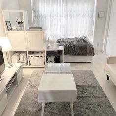 a living room filled with furniture and a white table in front of a tv on top of a hard wood floor